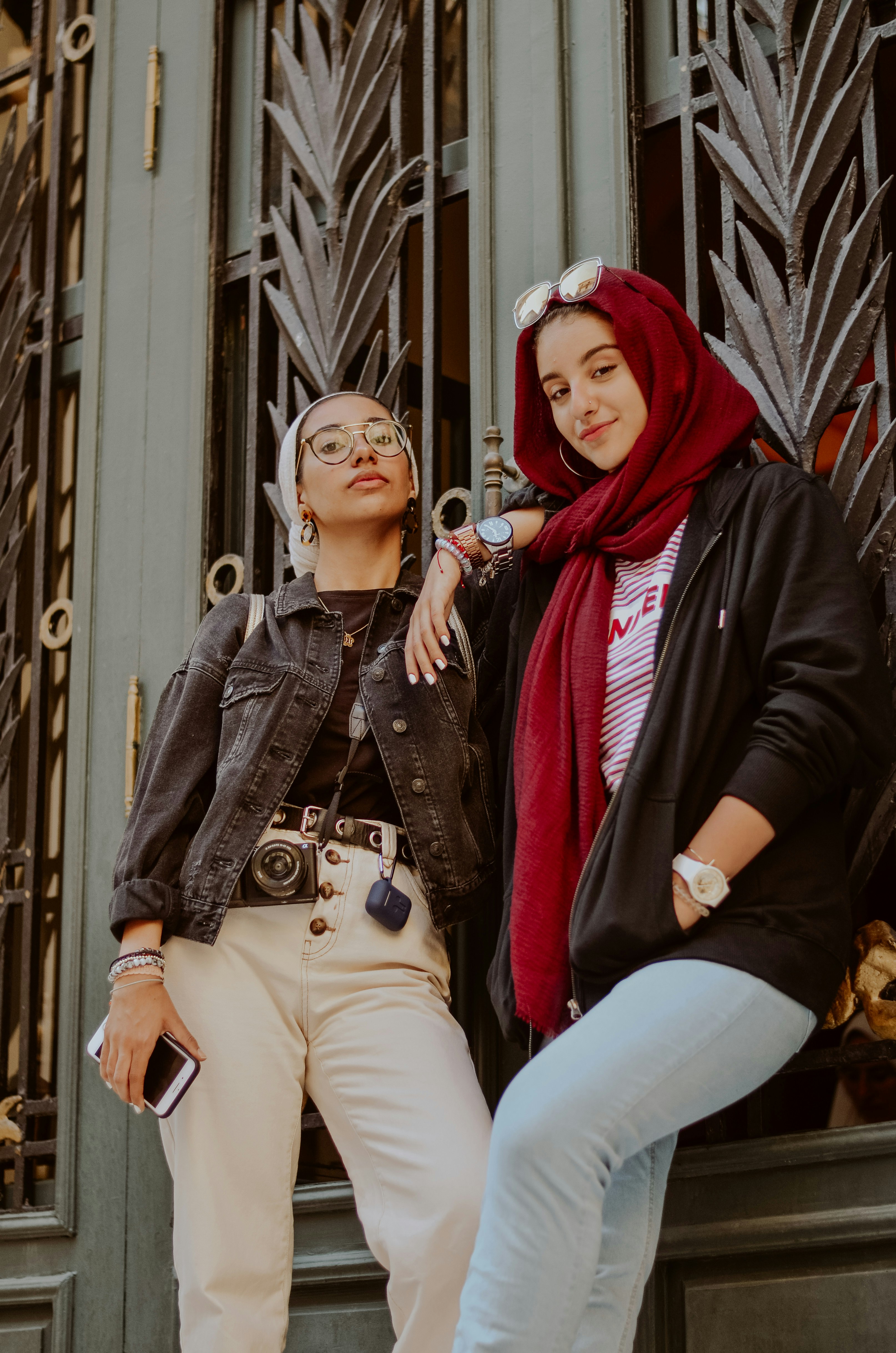 woman in black jacket sitting beside woman in white hijab